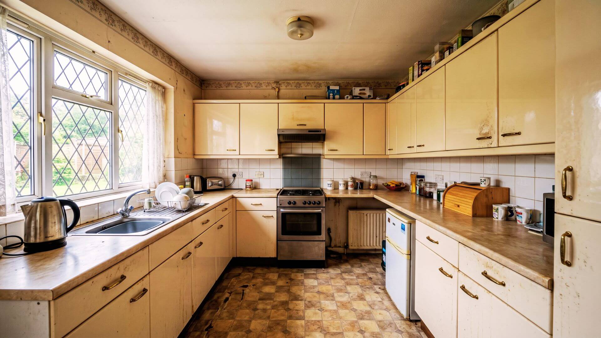 Before kitchen respray London – dated high-gloss magnolia cabinets with fingerprints