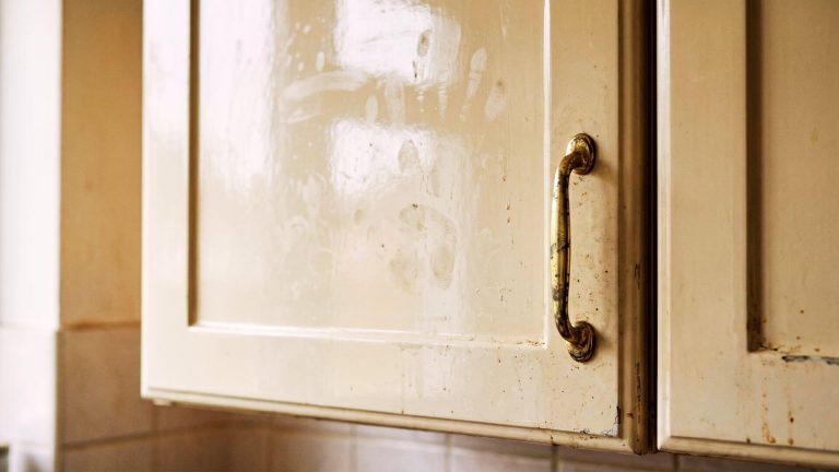 Before kitchen cabinet respray London – high-gloss magnolia with smudges and wear