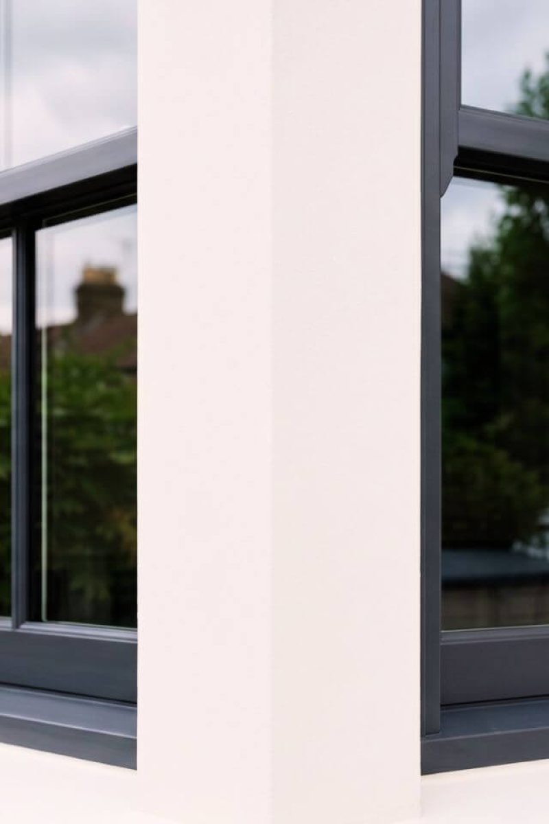 Exterior render spray painting London – close-up of warm white matt finish on render wall