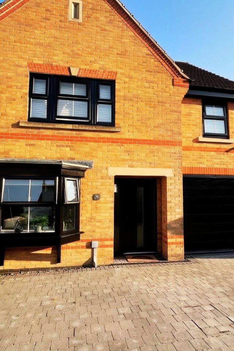 Exterior render spray painting London – close-up of dark matt finish on render wall